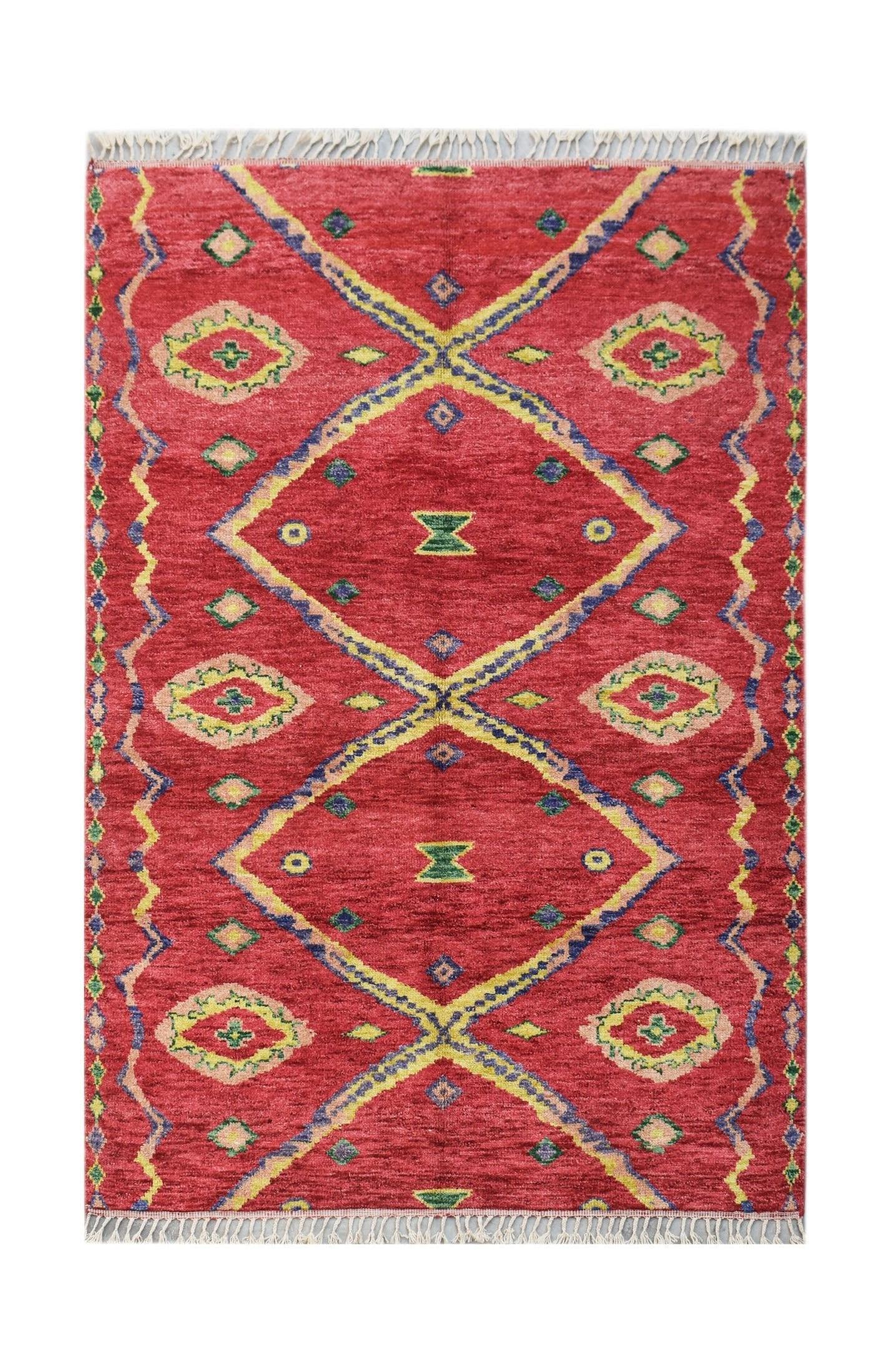 A hand-knotted Afghan wool rug featuring a red field with geometric diamond and tribal patterns.