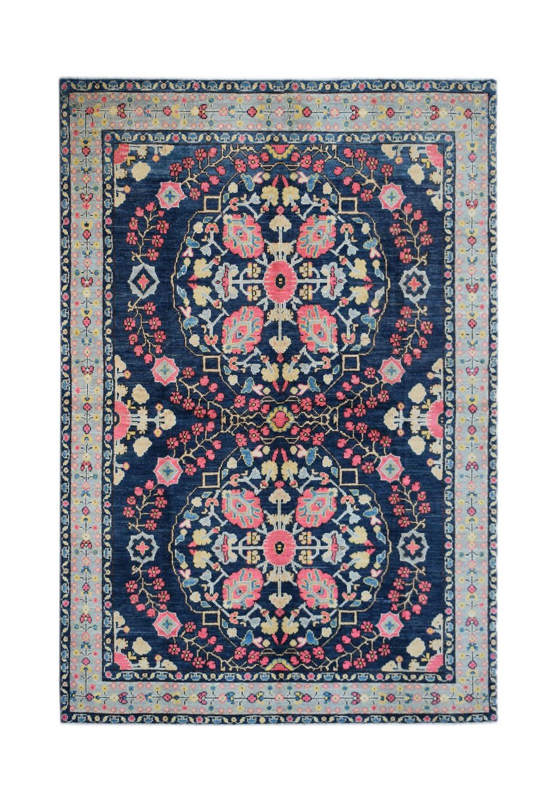 Handmade Afghan wool rug featuring a symmetrical floral medallion pattern in pink and blue.