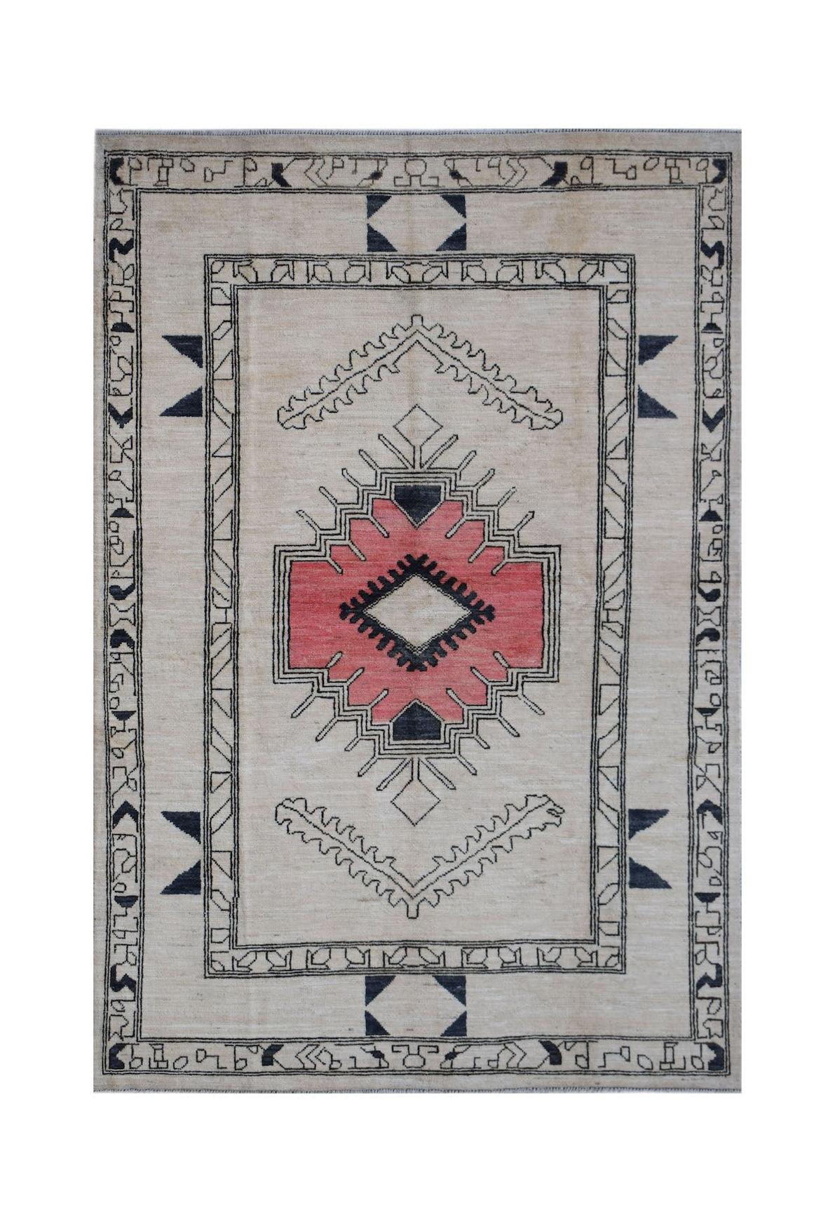 A handmade wool rug featuring a central pink geometric medallion on a cream background.