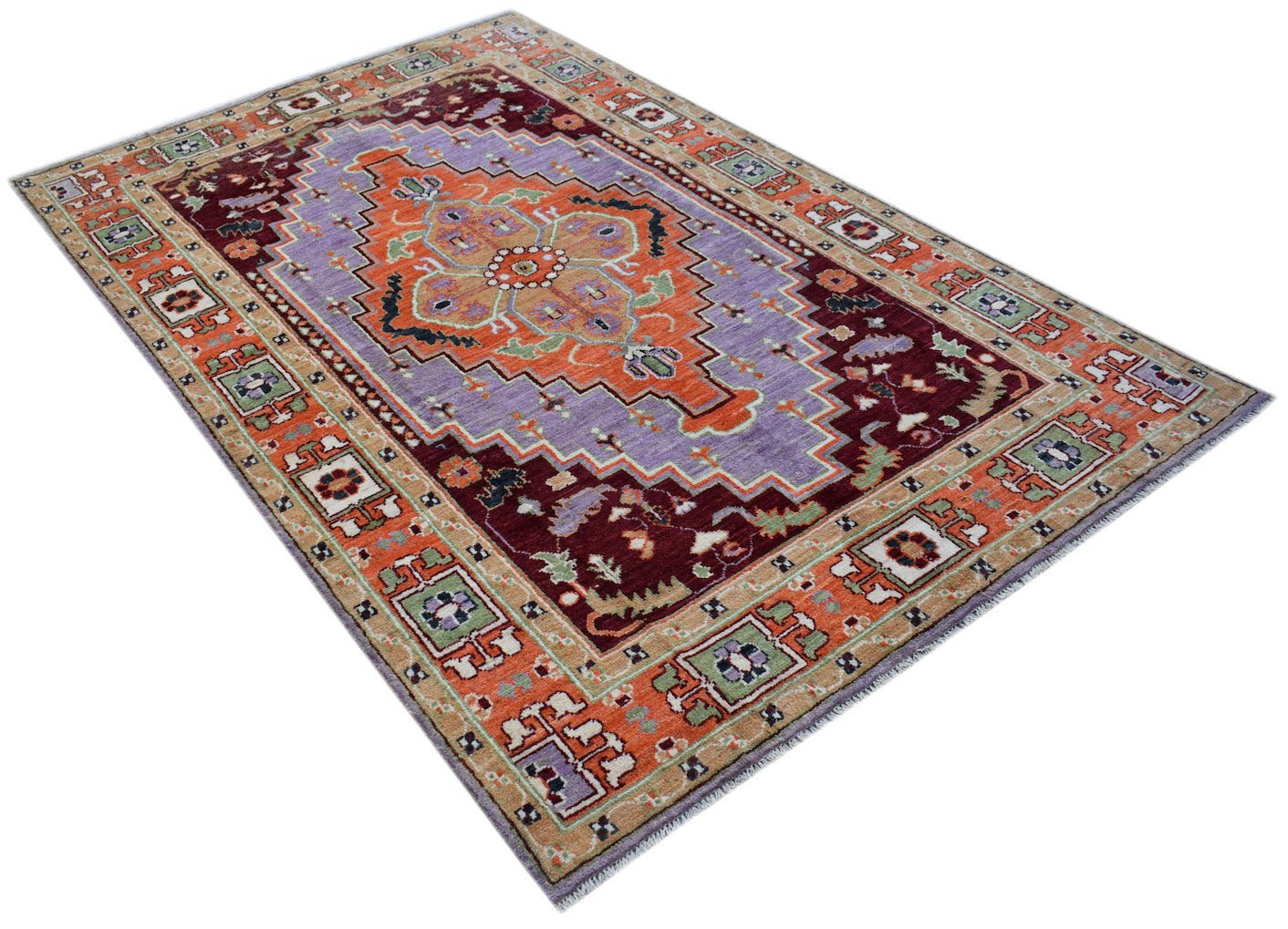 Handmade Afghan wool rug featuring a central orange medallion on a purple and deep red field.