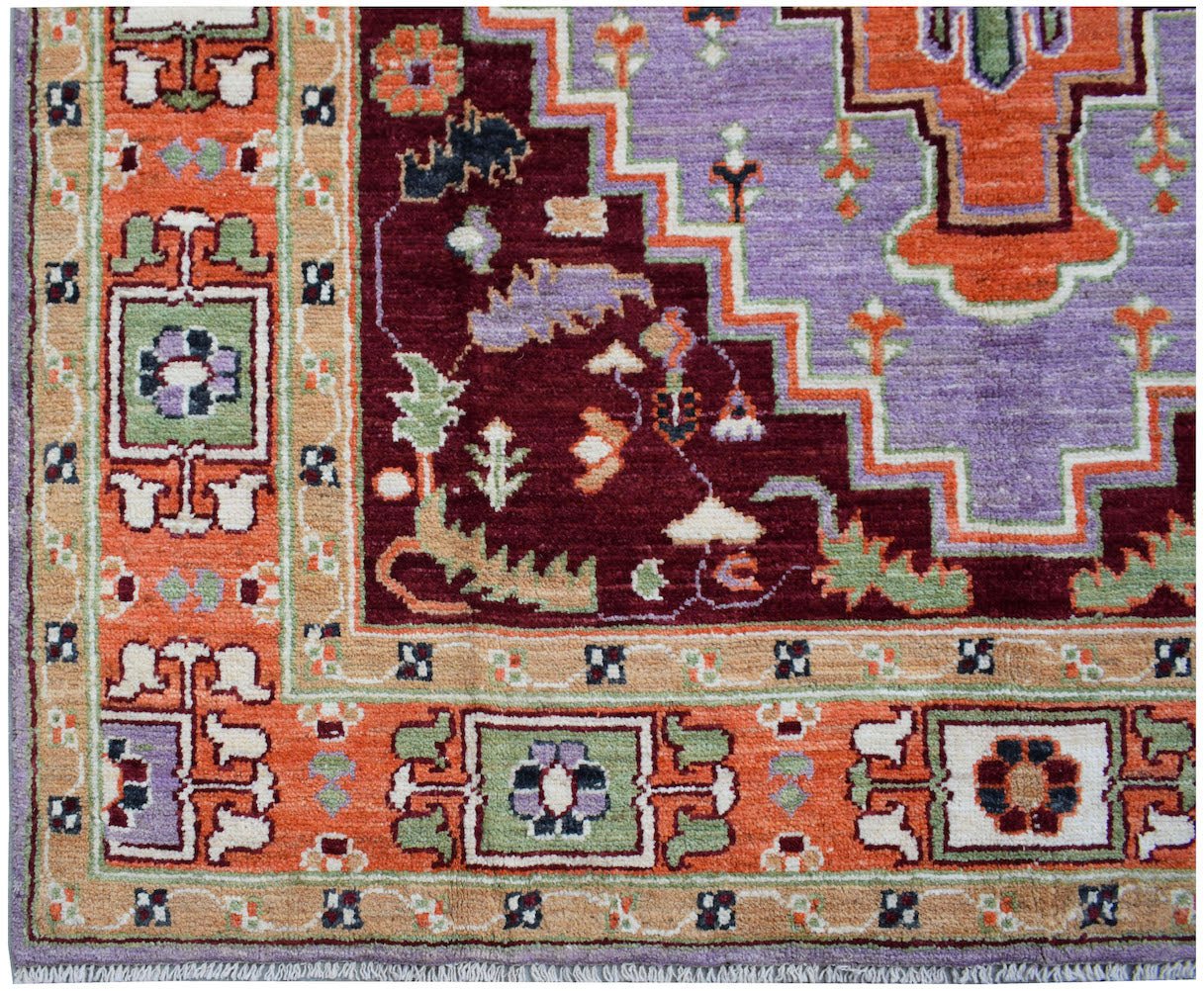 Handmade Afghan wool rug featuring a geometric pattern in shades of purple, orange, and burgundy.