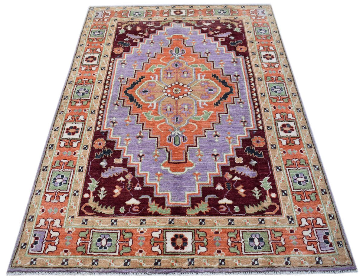 Handmade Afghan Pashm rug featuring a geometric medallion in orange, purple, and deep red.
