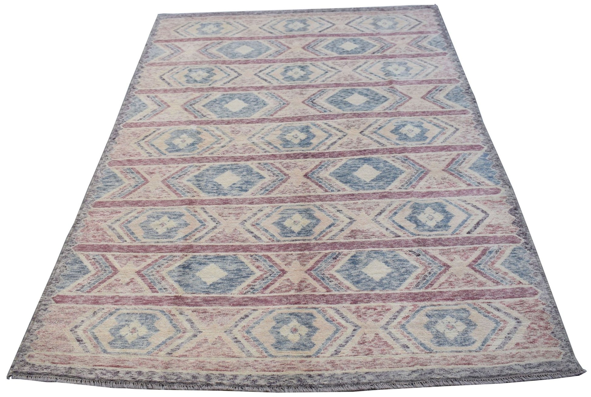 A handmade Afghan wool rug featuring a repeating geometric diamond pattern in blue and red tones.