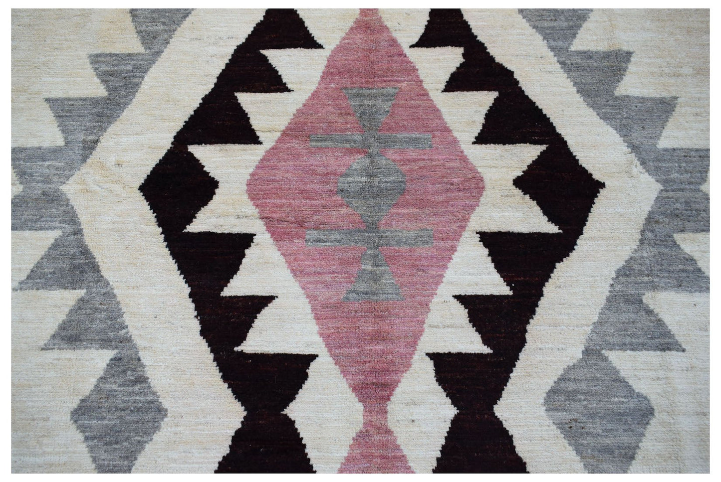 Handmade Afghan wool rug featuring a geometric diamond pattern in pink, grey, and dark brown.