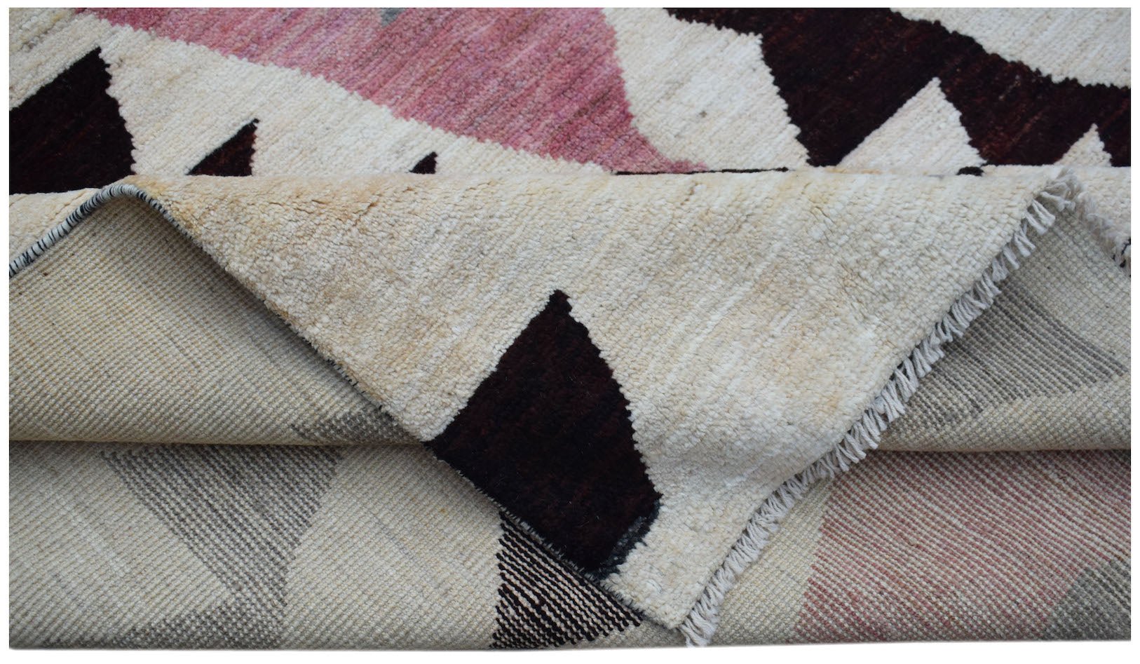 A handmade Afghan wool rug featuring a geometric pattern in pink, dark brown, and cream.