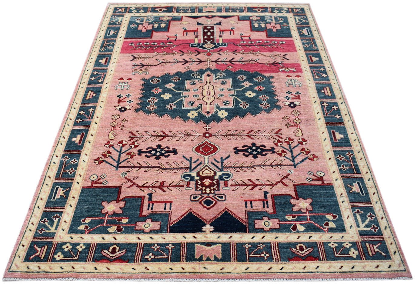 Handmade Afghan Pashm wool rug featuring a pink field with blue geometric tribal motifs.