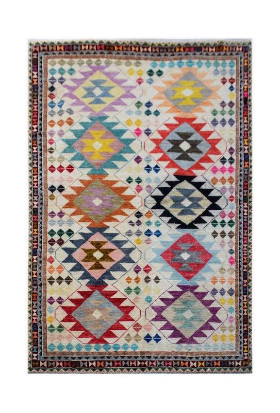 Handmade Afghan wool rug featuring a colorful geometric diamond pattern on a cream background.