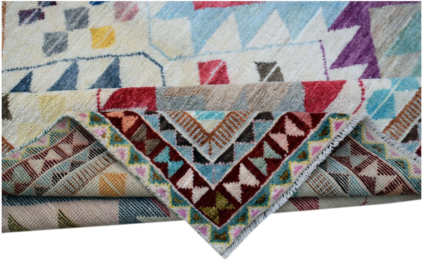 A handmade Afghan wool rug featuring a colorful geometric tribal pattern folded to show detail.