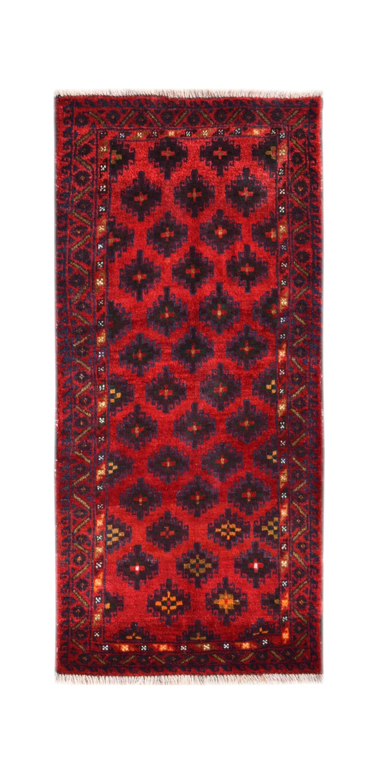 A vintage Afghan Baluch rug featuring a repeating geometric pattern in deep red and dark blue.