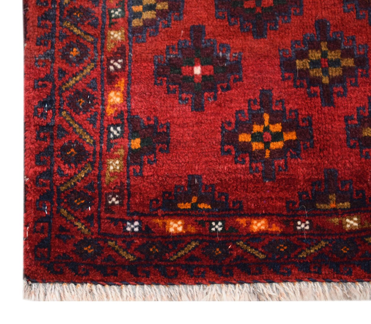 A vintage Afghan Baluch rug featuring geometric diamond motifs in red, blue, and gold wool.