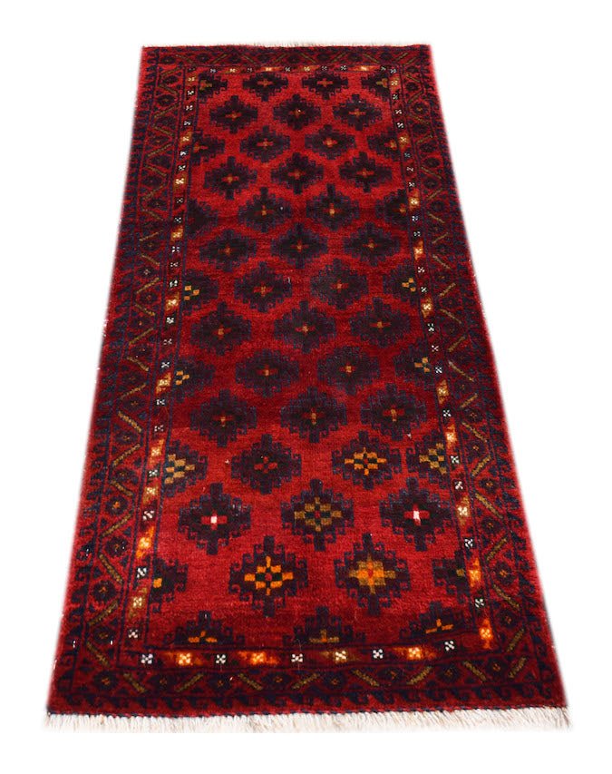 A vintage handmade Afghan Baluch rug featuring a repeating geometric pattern in deep red and black.