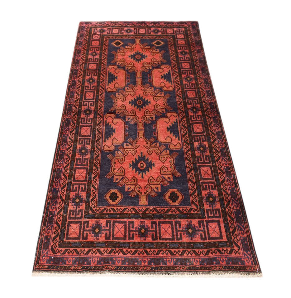 A handmade vintage Afghan Baluch rug featuring geometric patterns in red and dark blue.