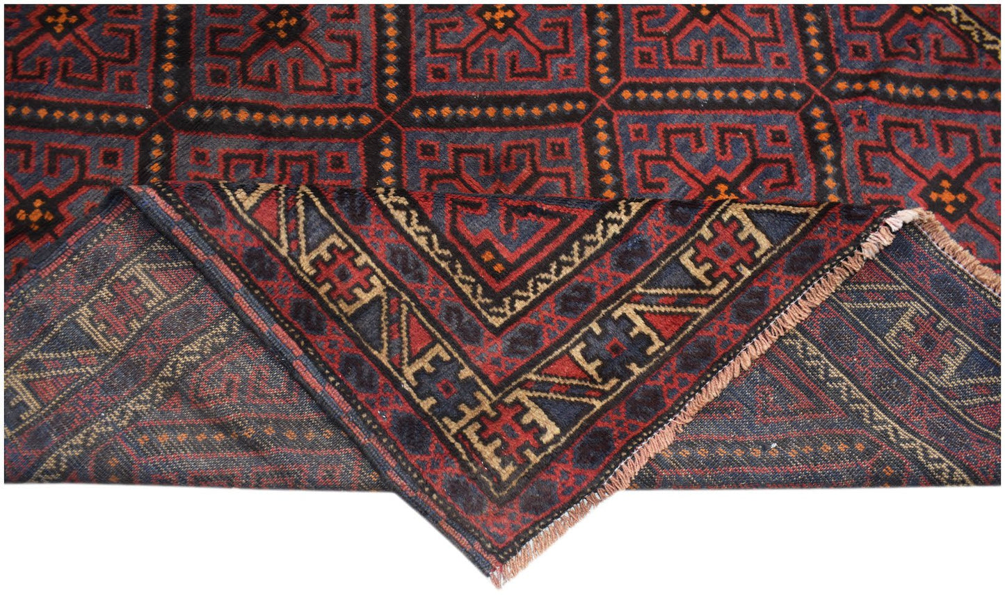 A vintage handmade Afghan Baluch rug featuring a geometric pattern in red and dark blue tones.