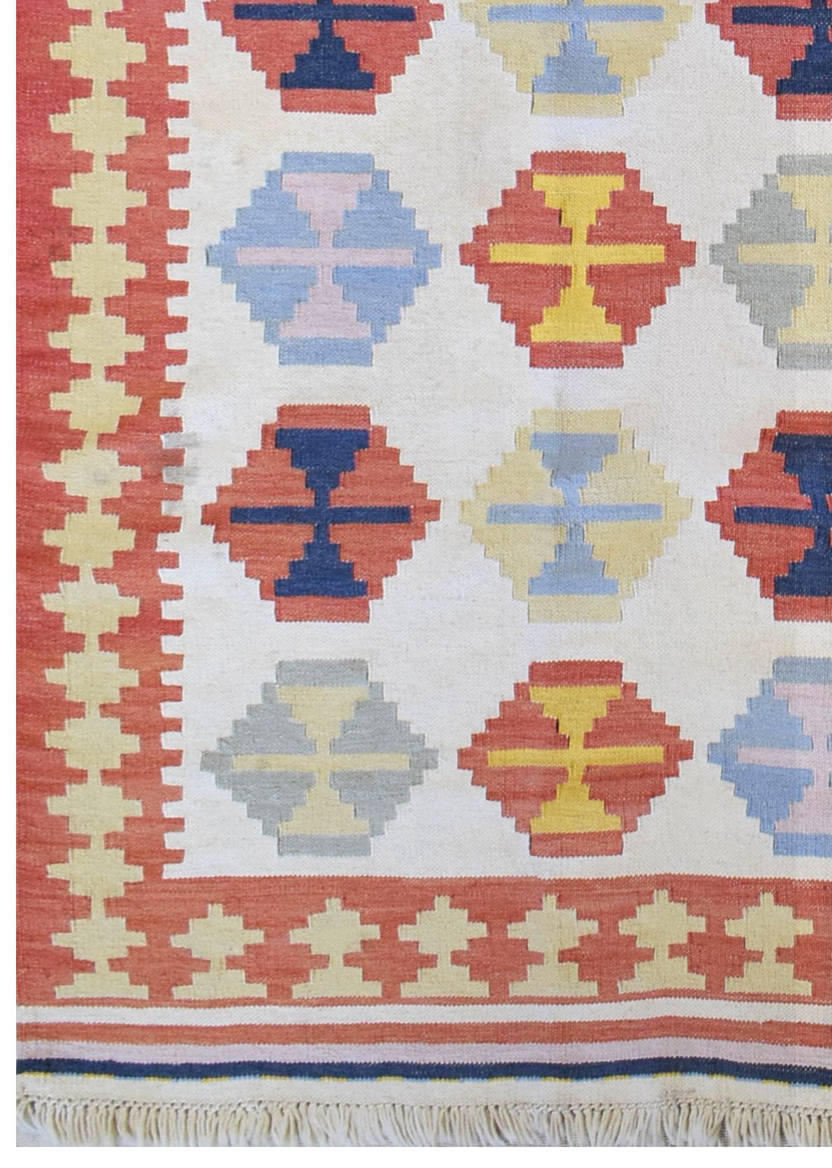 A handmade Turkish kilim rug featuring a geometric pattern of colorful octagons on a cream field.
