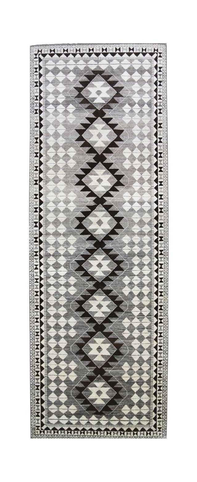 An Afghan Chobi runner rug featuring a geometric diamond pattern in shades of grey and white.