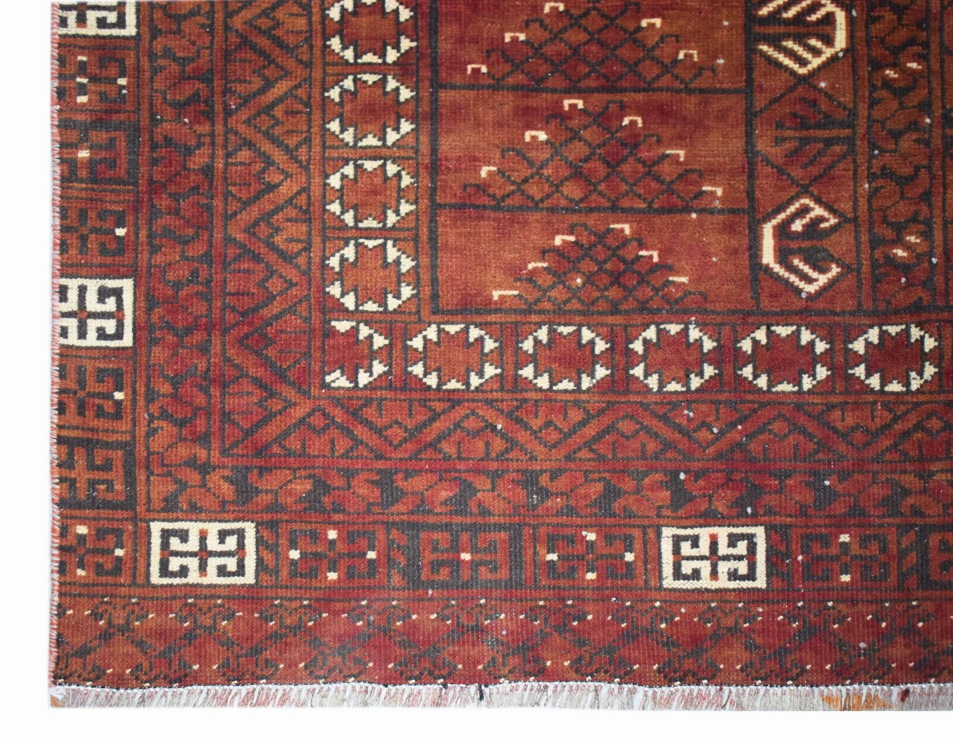 A vintage handwoven Afghan Turkmen rug featuring traditional geometric patterns in red and black.