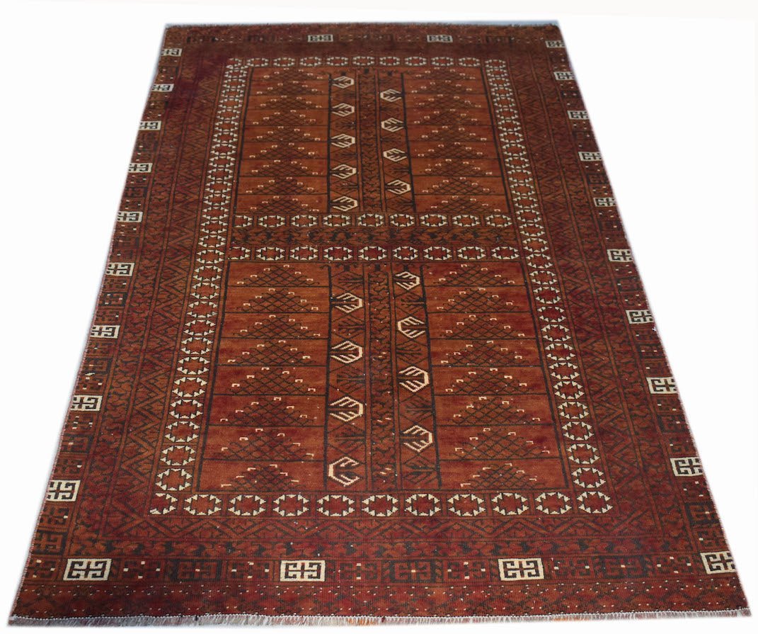 A handwoven vintage Afghan Turkmen rug featuring a geometric pattern in shades of red and brown.