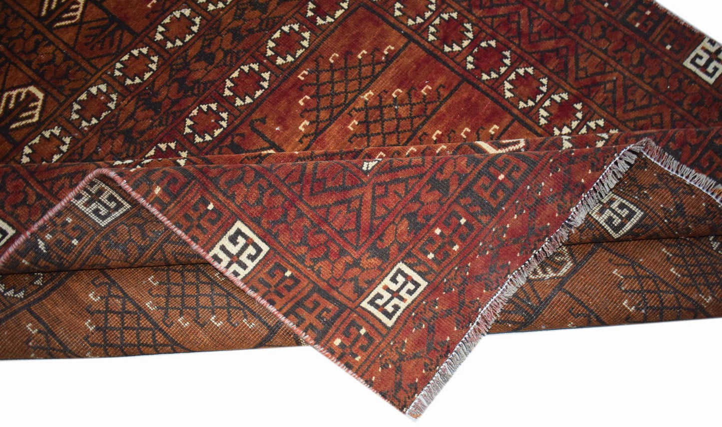 A handwoven vintage Afghan Turkmen rug featuring traditional geometric patterns in deep red tones.