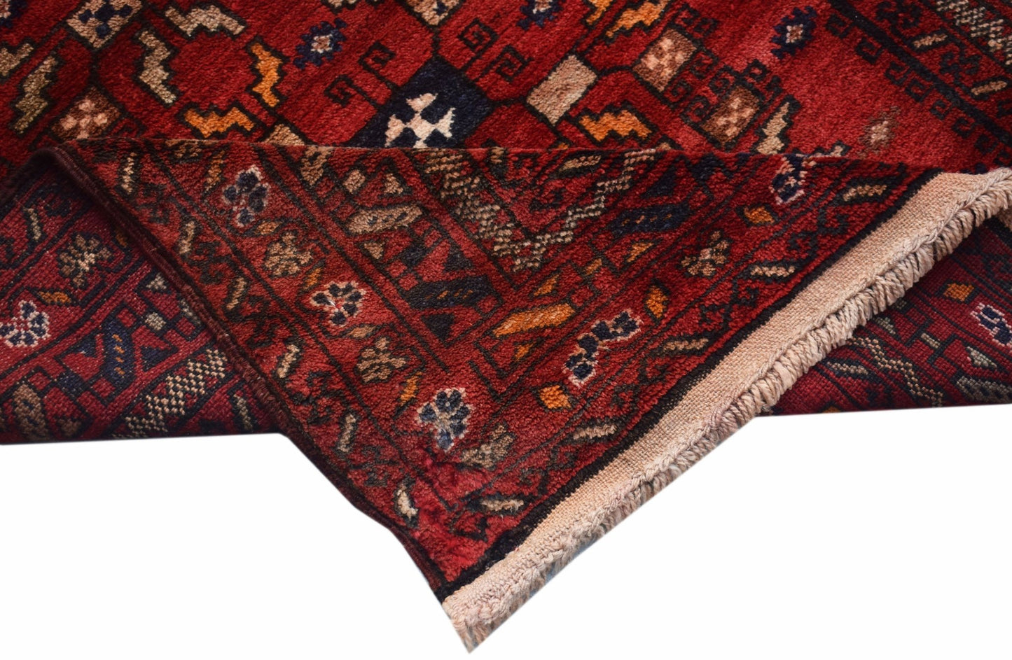 A handwoven vintage Afghan Baluch rug featuring a geometric red pattern and fringed edges.