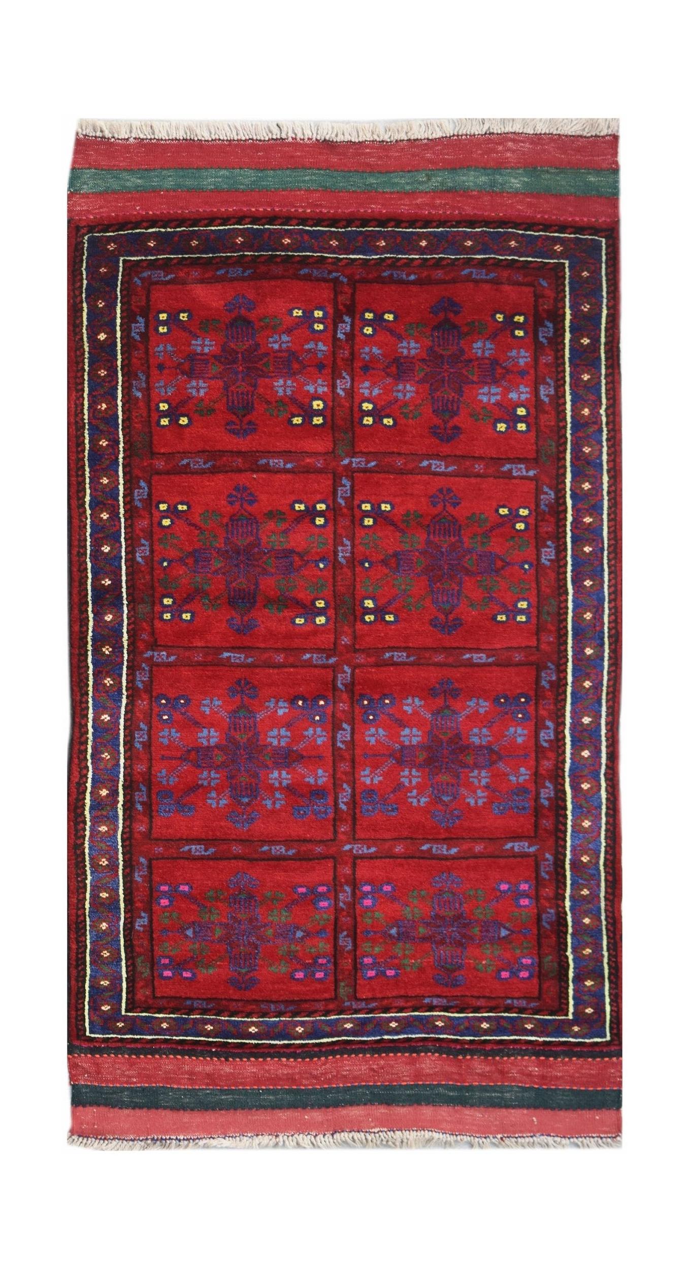 A vintage handwoven Afghan Baluch rug featuring a red field with repeating geometric floral motifs.
