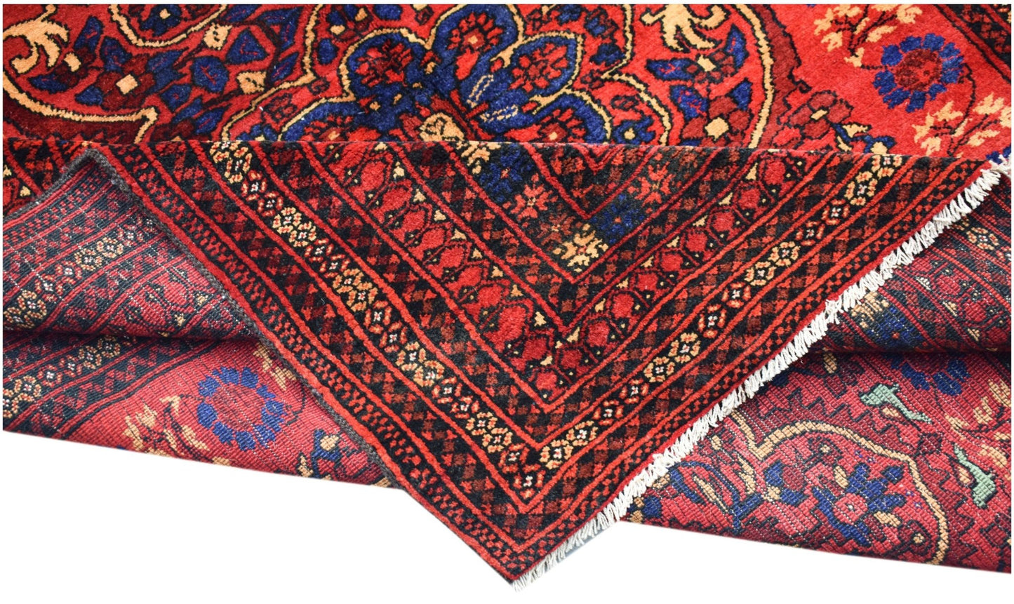 A vintage handwoven Afghan Baluch rug featuring a traditional red and blue geometric pattern.