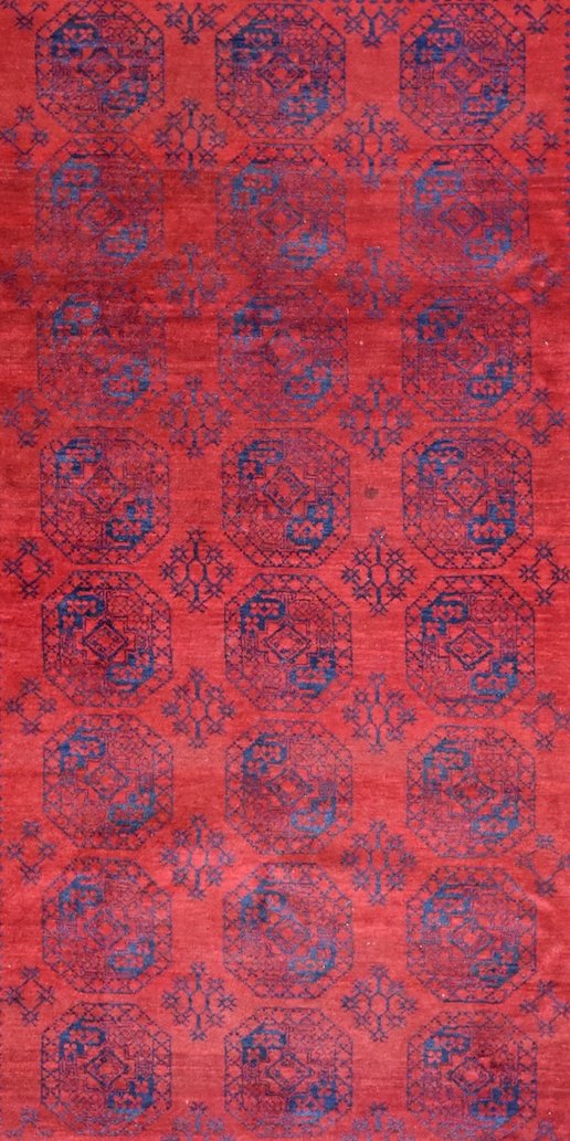 A vintage handmade Afghan Turkmen rug featuring a repeating geometric pattern in red and blue.
