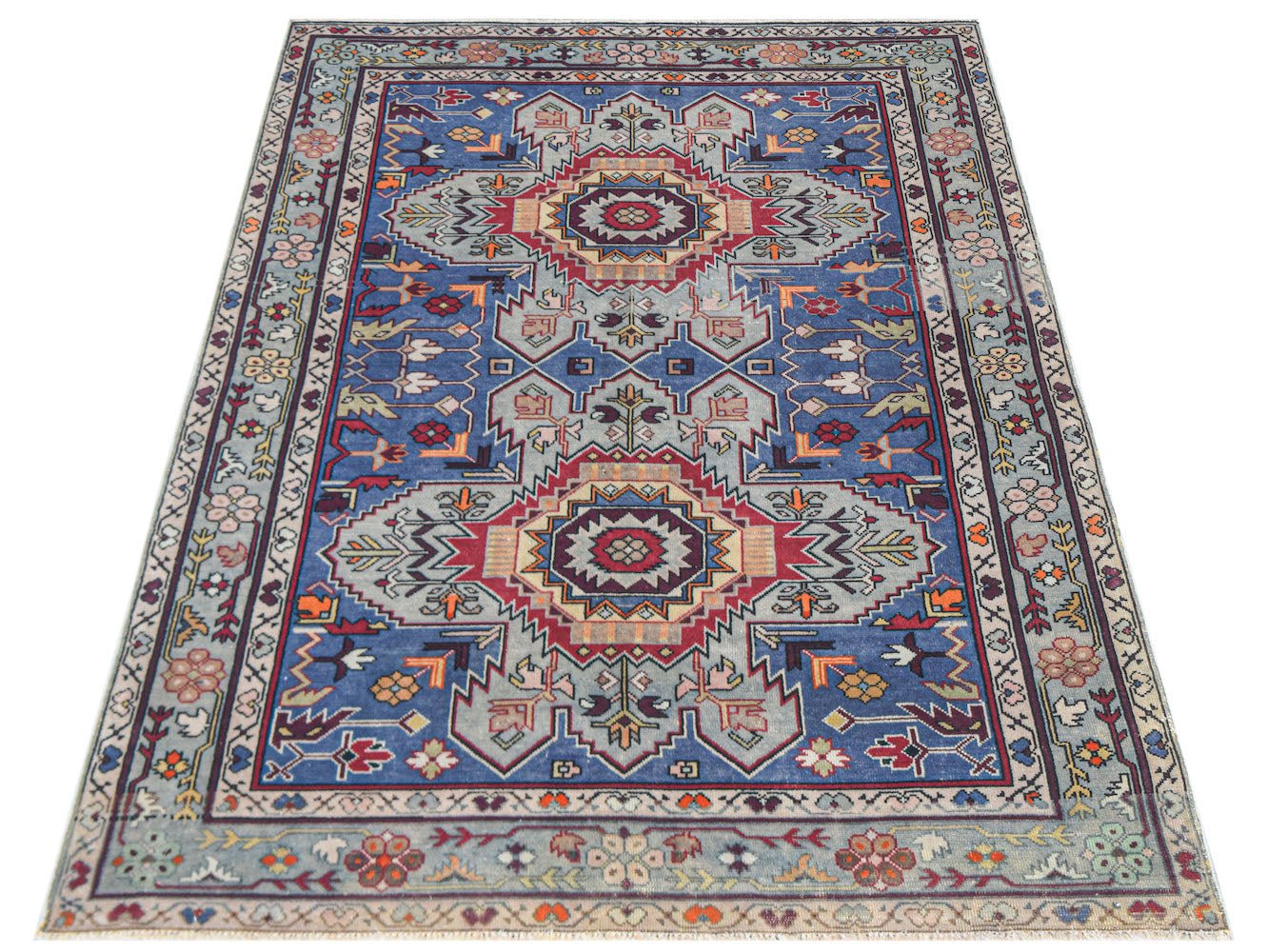 Vintage Caucasian rug with a blue field and geometric patterns.