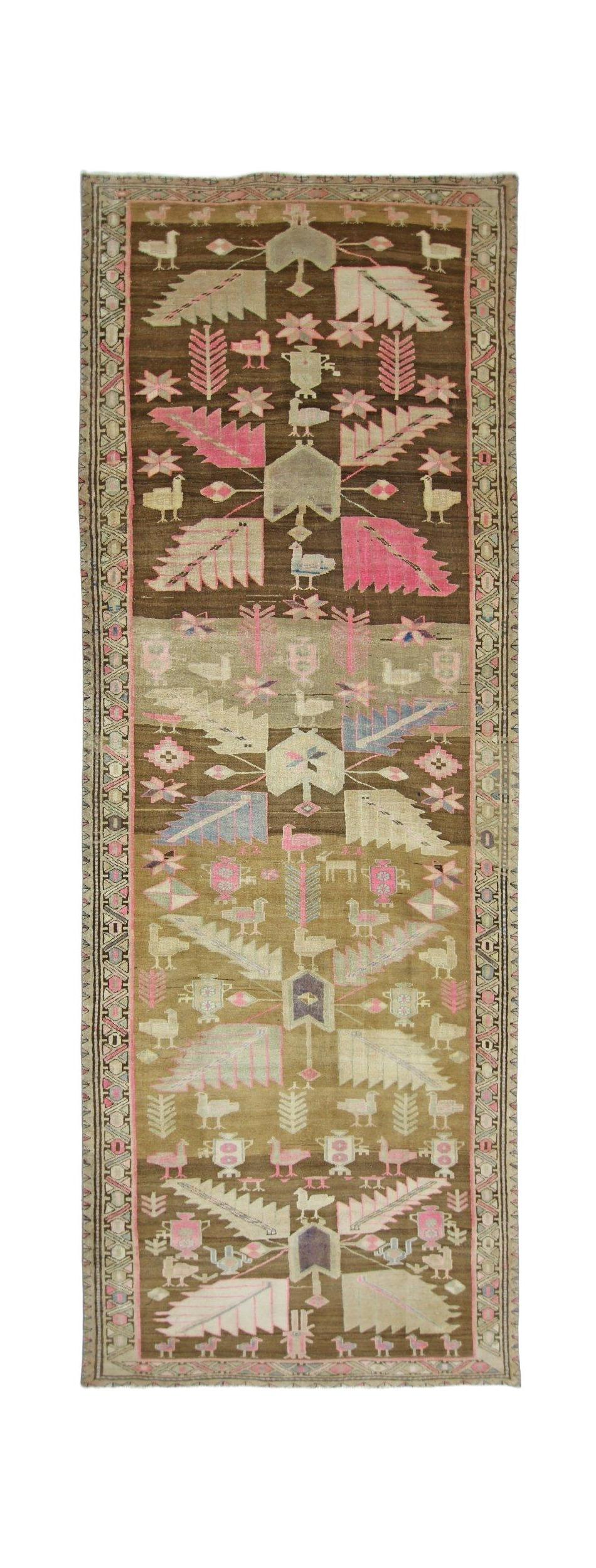 A vintage Caucasian runner rug featuring a traditional bird and leaf pattern in pink and brown.
