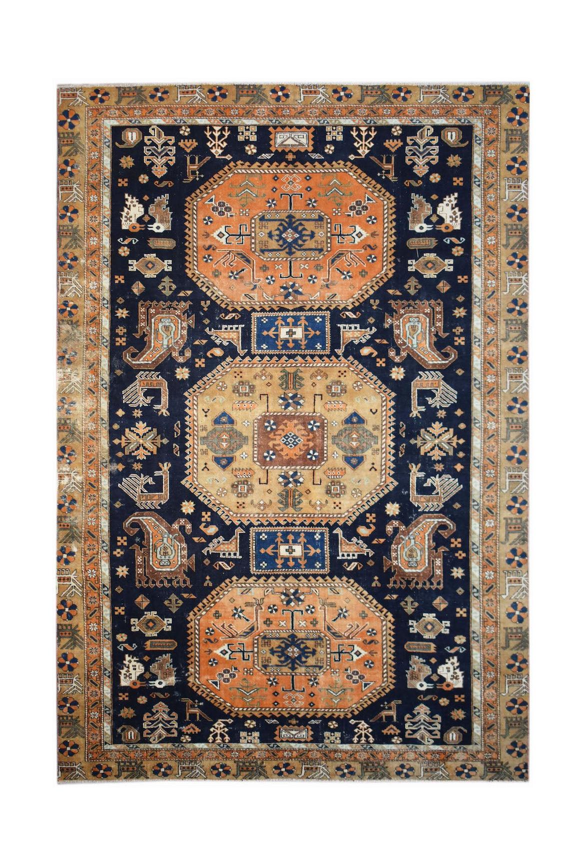 A handwoven vintage Caucasian rug featuring geometric patterns in orange, blue, and tan.