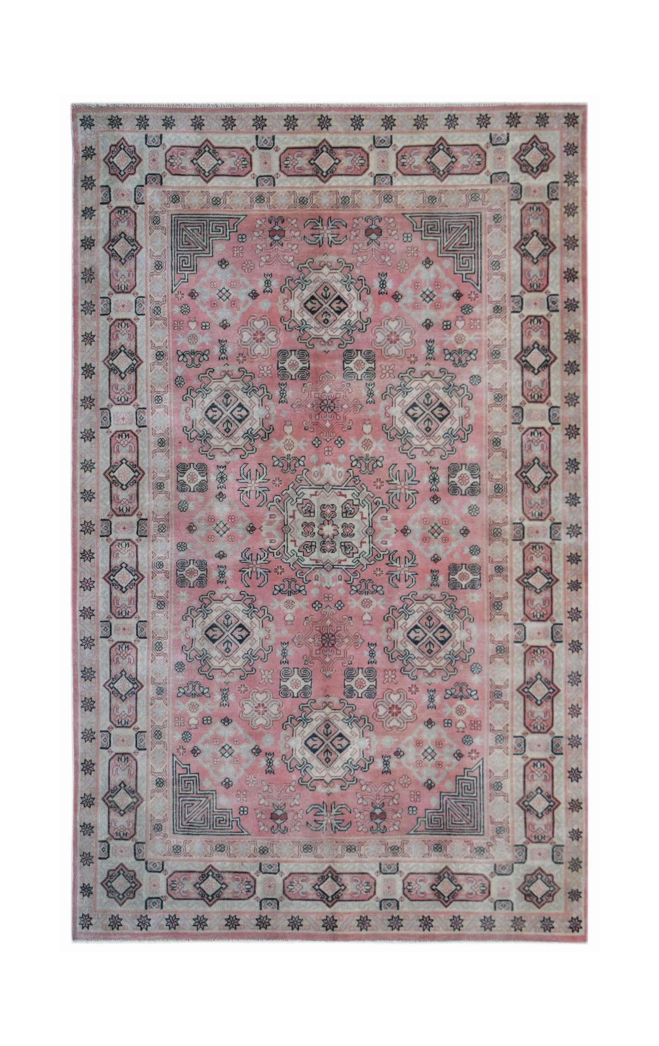A vintage handwoven Chinese rug featuring a pink field with intricate geometric and floral patterns.