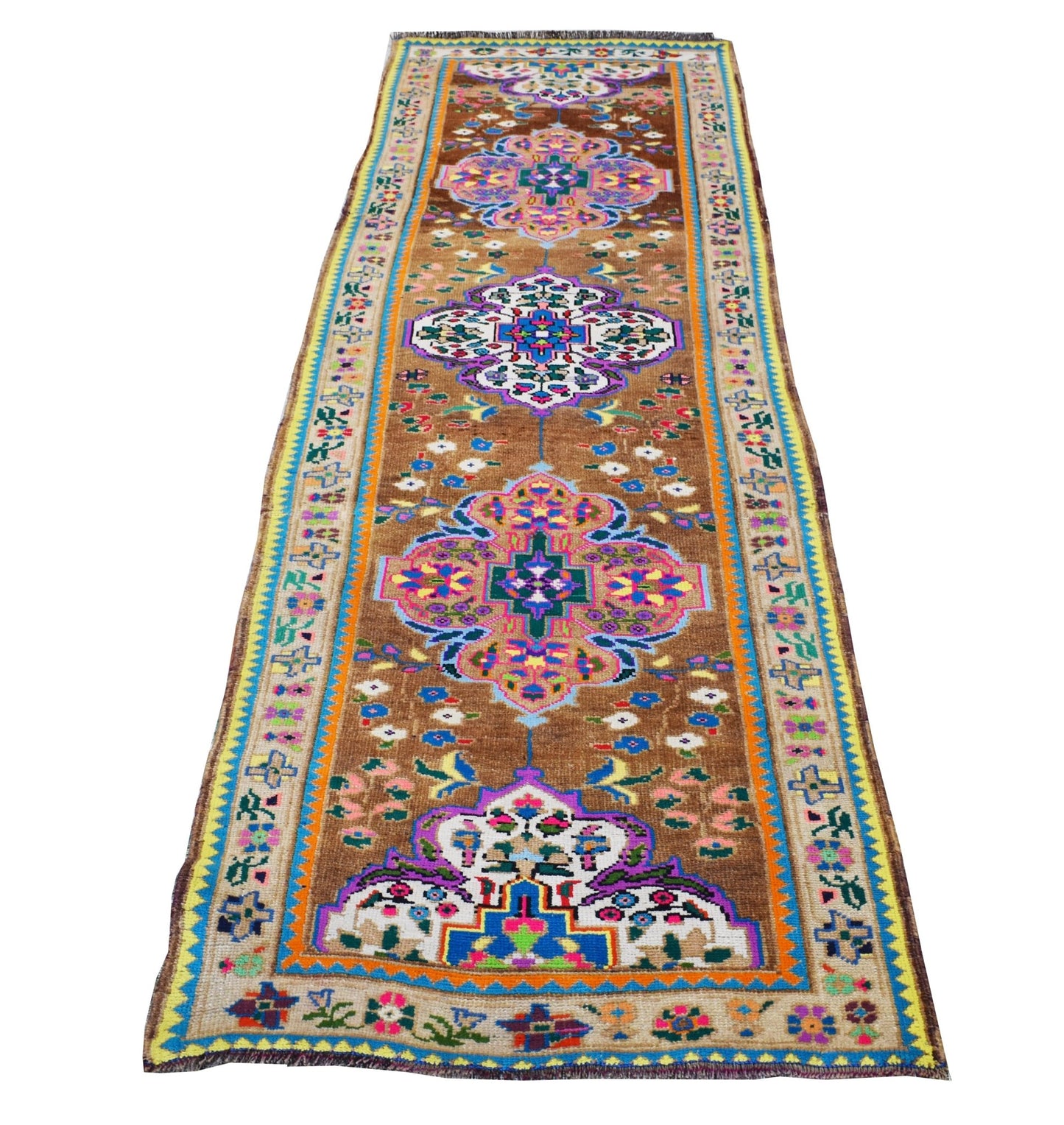 A vintage Kurdish Herki runner featuring colorful tribal motifs on a brown wool background.