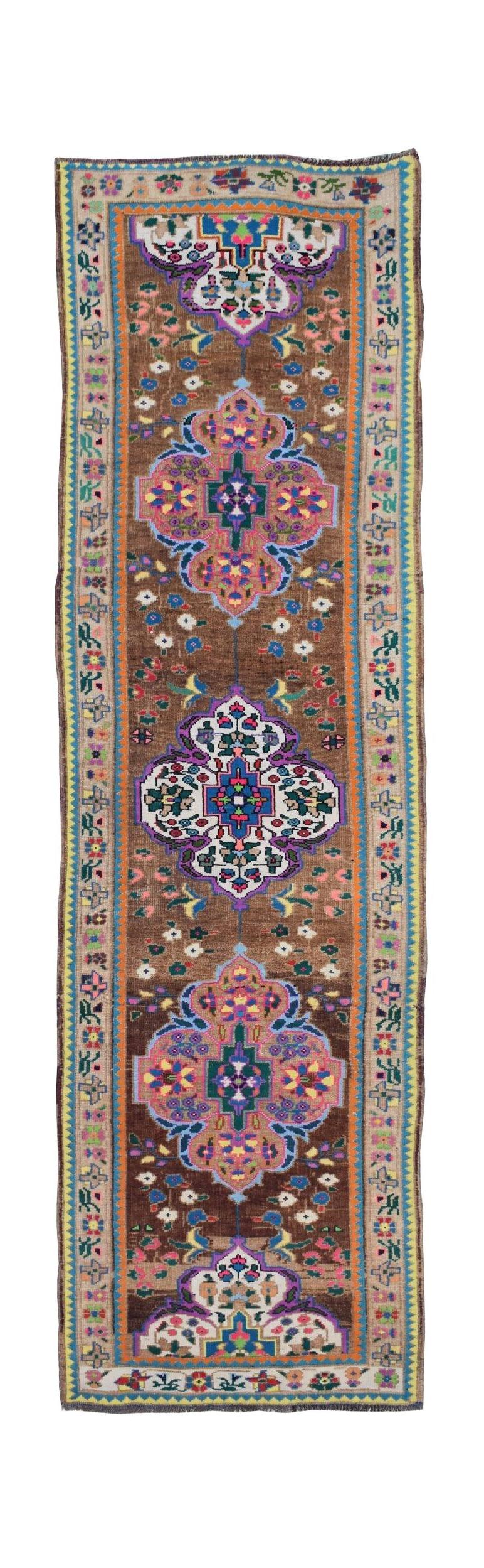 A vintage handmade Kurdish Herki runner featuring tribal motifs in a vibrant, multi-colored palette.