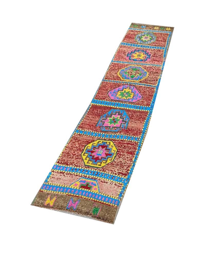 A vintage handmade Kurdish Herki runner featuring colorful geometric medallions on a red field.