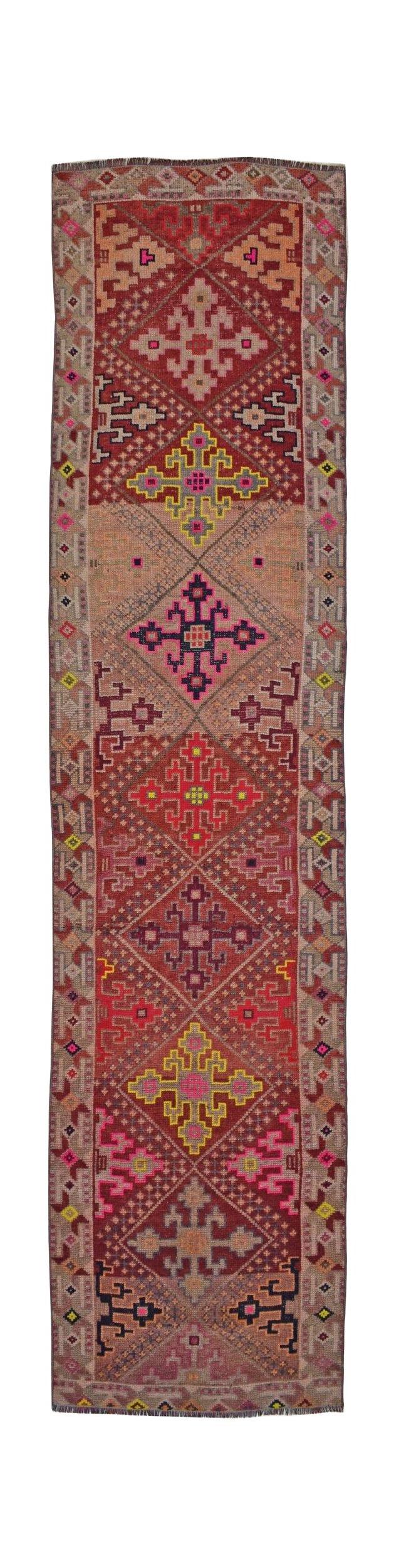 A vintage Kurdish Herki runner featuring geometric tribal motifs in vibrant wool and nylon.