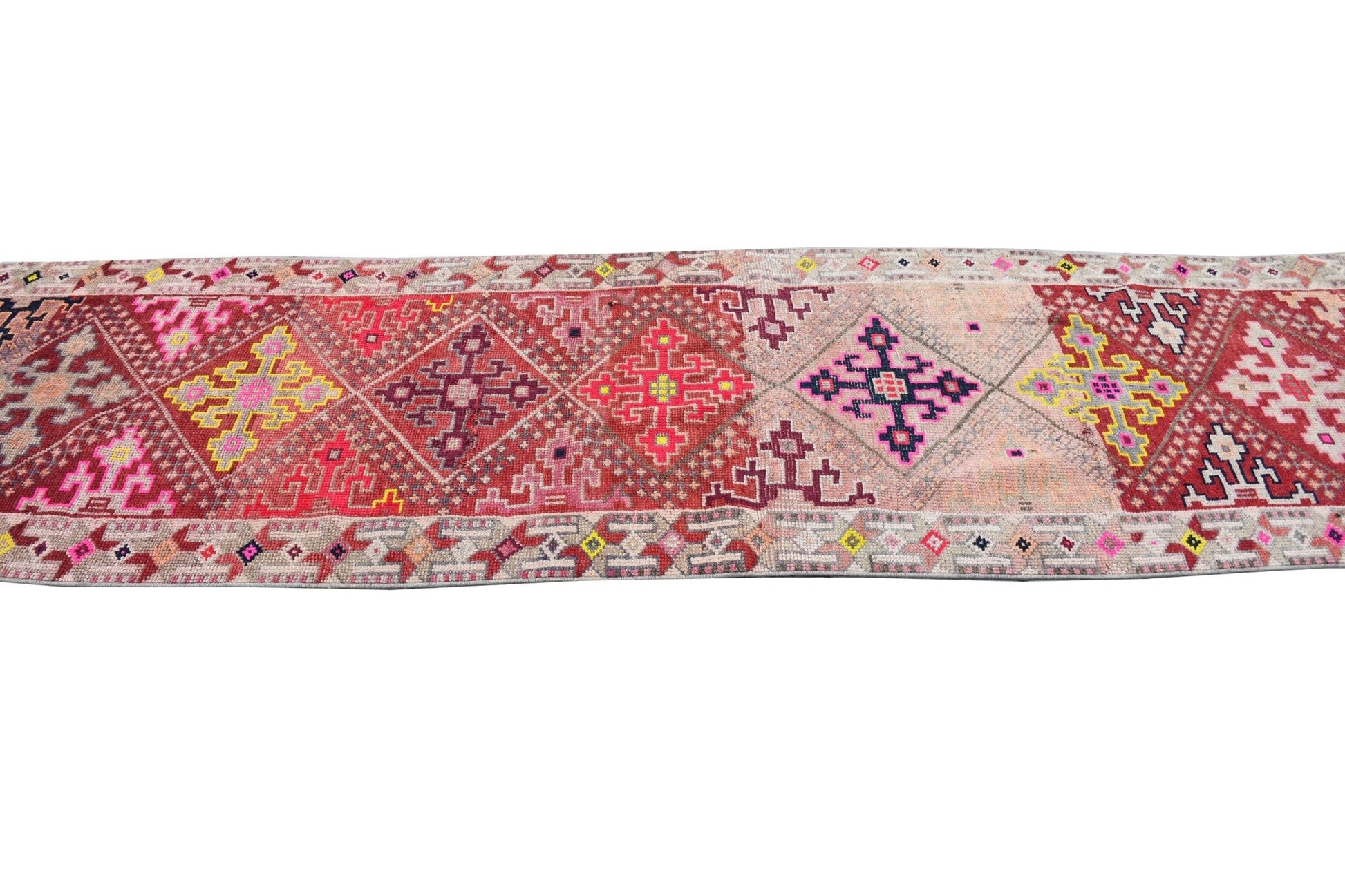 A vintage Kurdish Herki runner featuring geometric tribal motifs in vibrant, multicolored wool.