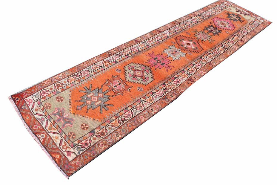 Vintage Kurdish Herki runner with tribal motifs in orange and grey.
