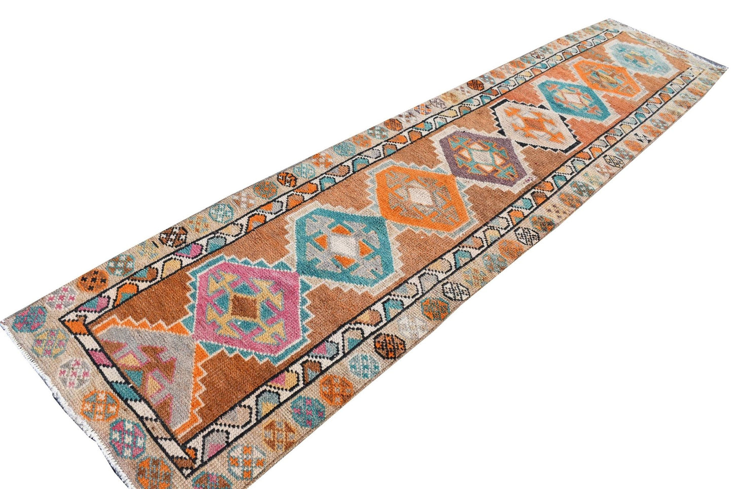 A vintage Kurdish Herki runner featuring tribal geometric motifs in vibrant, multicolored wool.