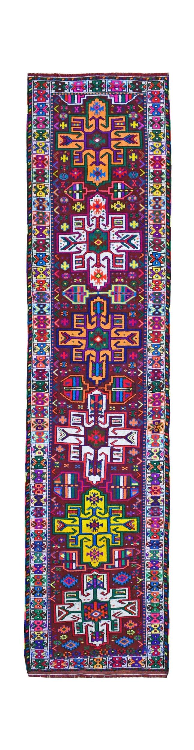 A vintage Kurdish Herki runner featuring vibrant tribal motifs on a dark wool background.