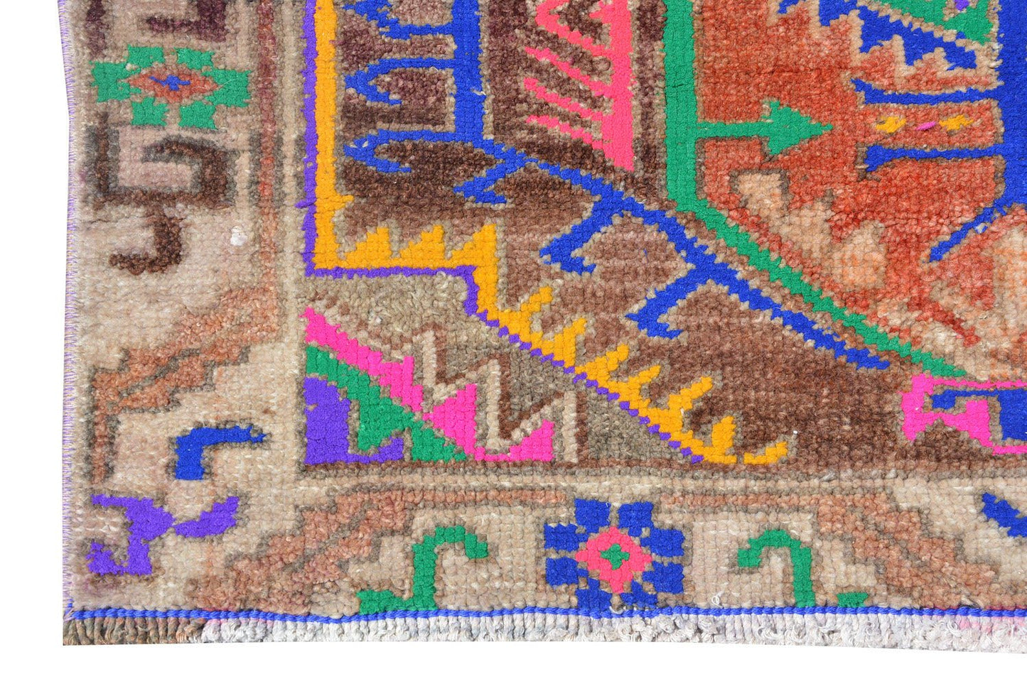 A vintage Kurdish Herki runner featuring tribal motifs in vibrant neon and earthy wool tones.