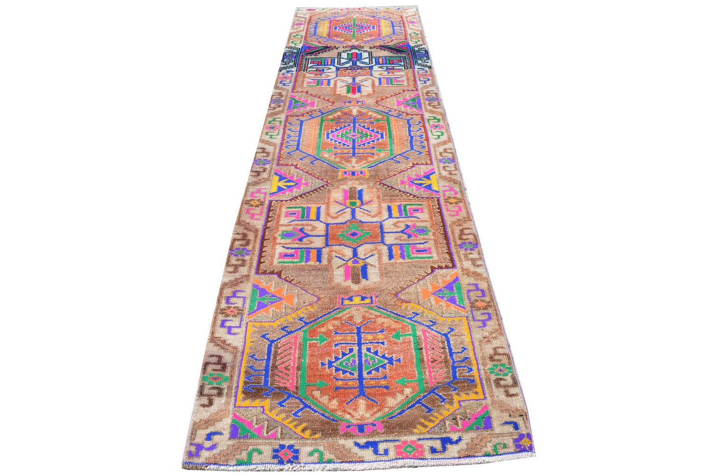 A vintage Kurdish Herki runner featuring tribal motifs in vibrant neon colors on a brown wool base.