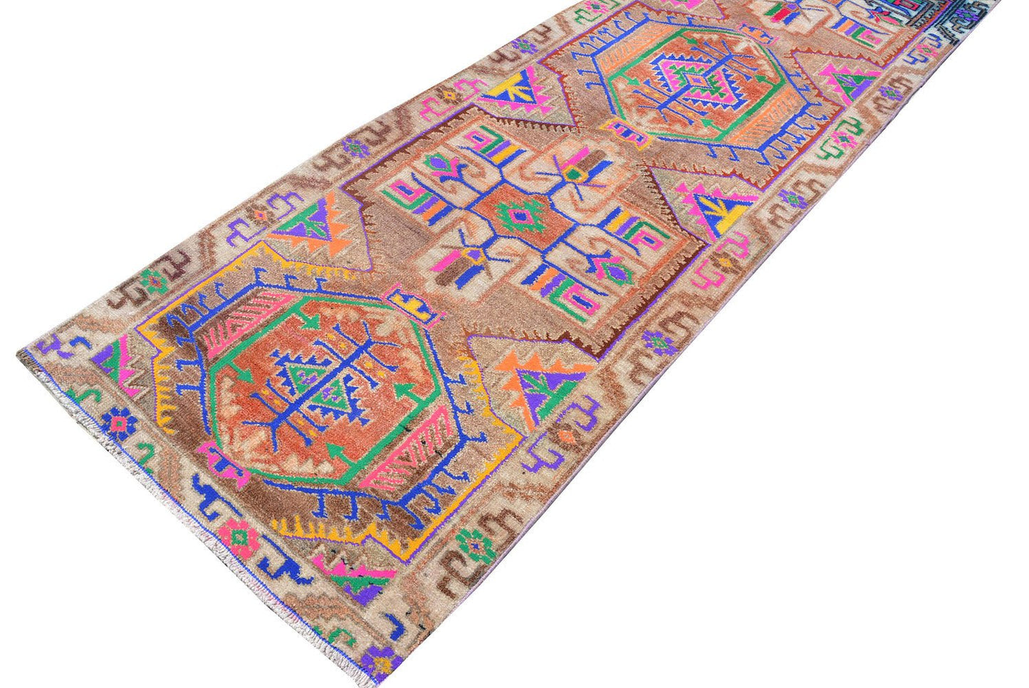 A vintage Kurdish Herki runner featuring tribal motifs in vibrant neon colors on a brown wool base.