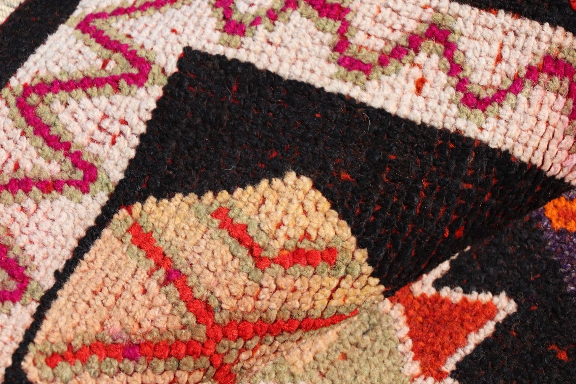 A close-up of a vintage Kurdish Herki runner featuring tribal motifs in vibrant wool and nylon.