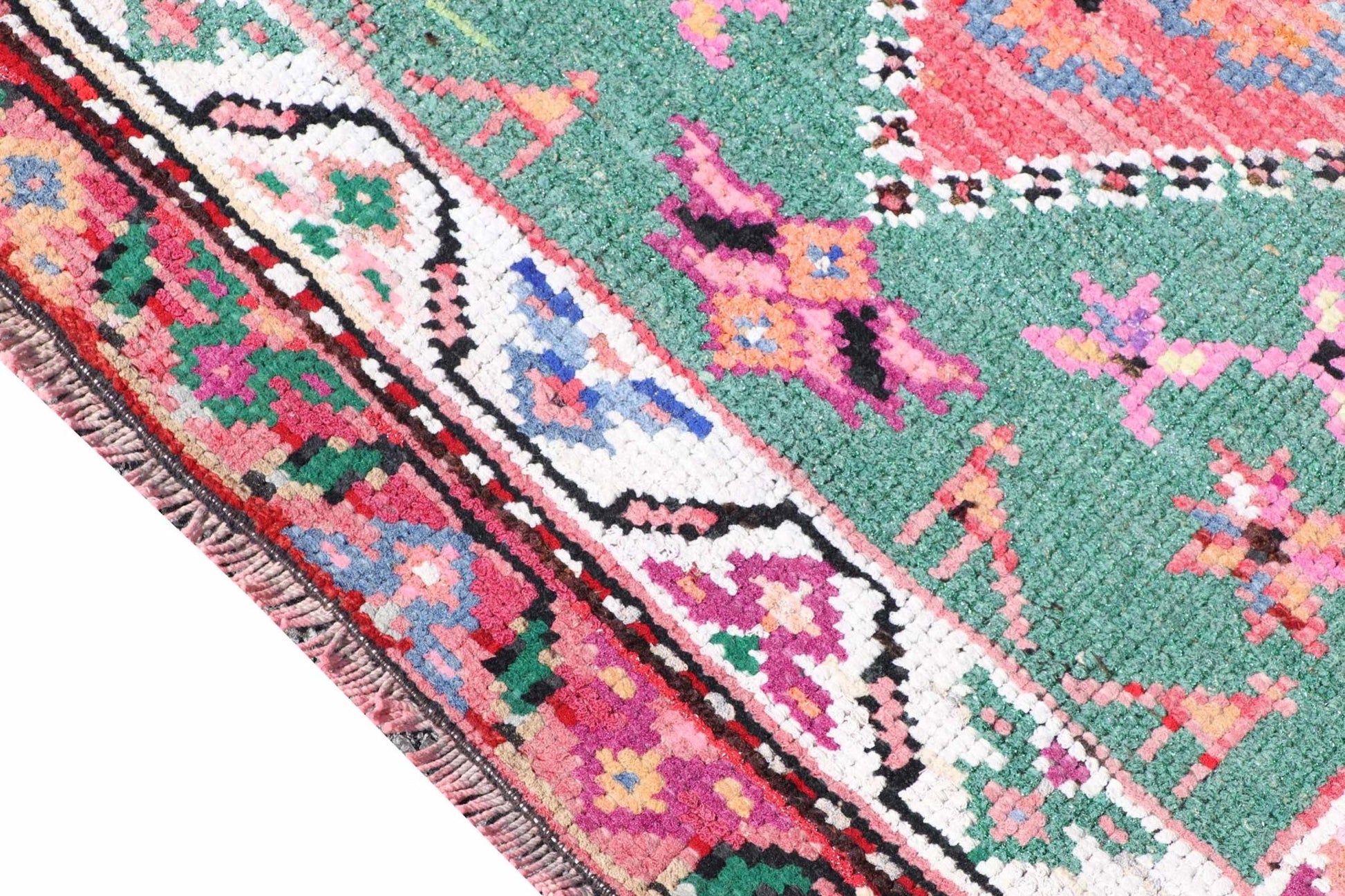 A vintage Kurdish Herki runner featuring tribal motifs in vibrant neon colors on a green background.