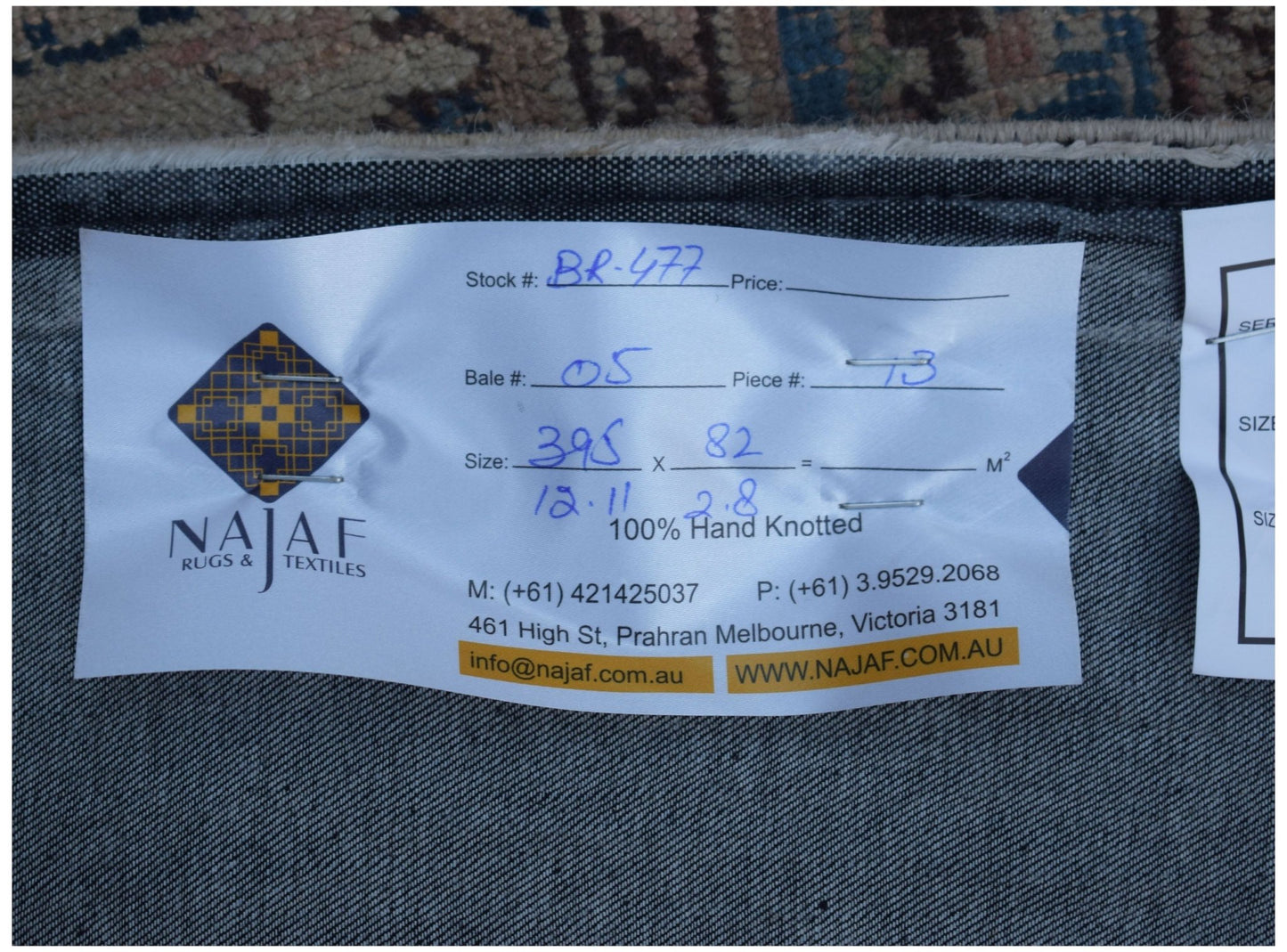 A close-up view of the underside of a vintage patchwork runner showing the product label.