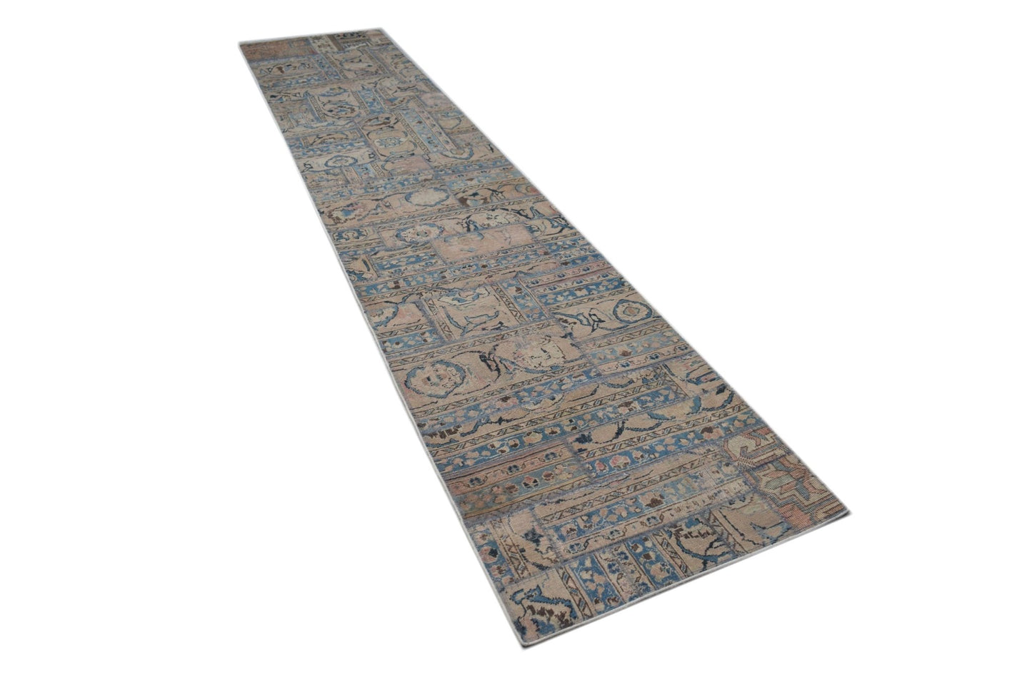 A long, handmade vintage patchwork runner rug featuring a faded blue and beige geometric pattern.