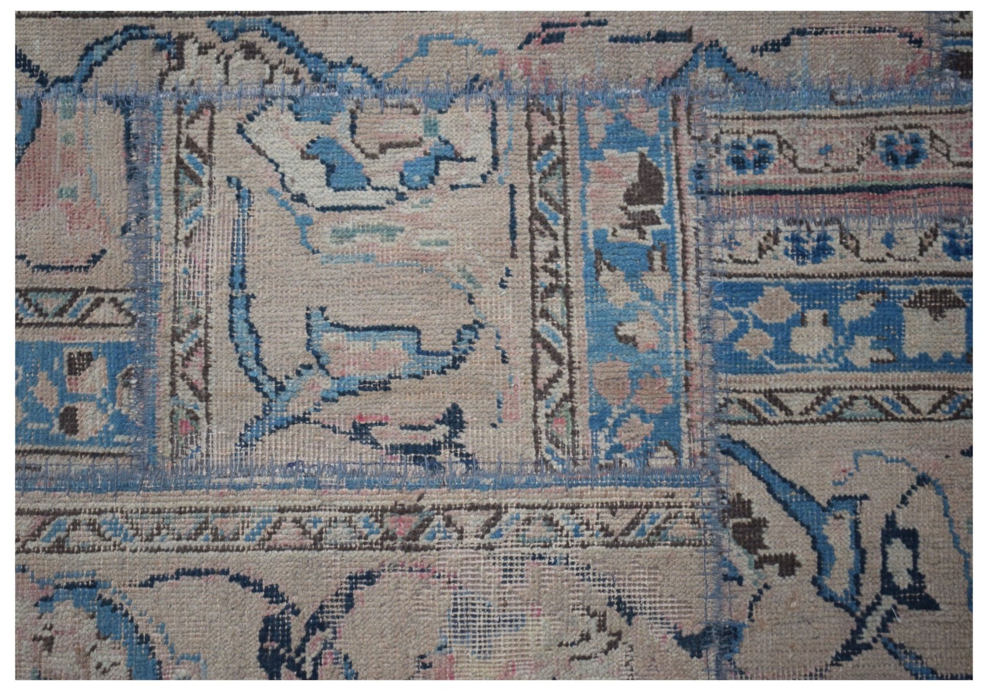 A handmade vintage patchwork runner featuring faded blue, pink, and brown wool patterns.