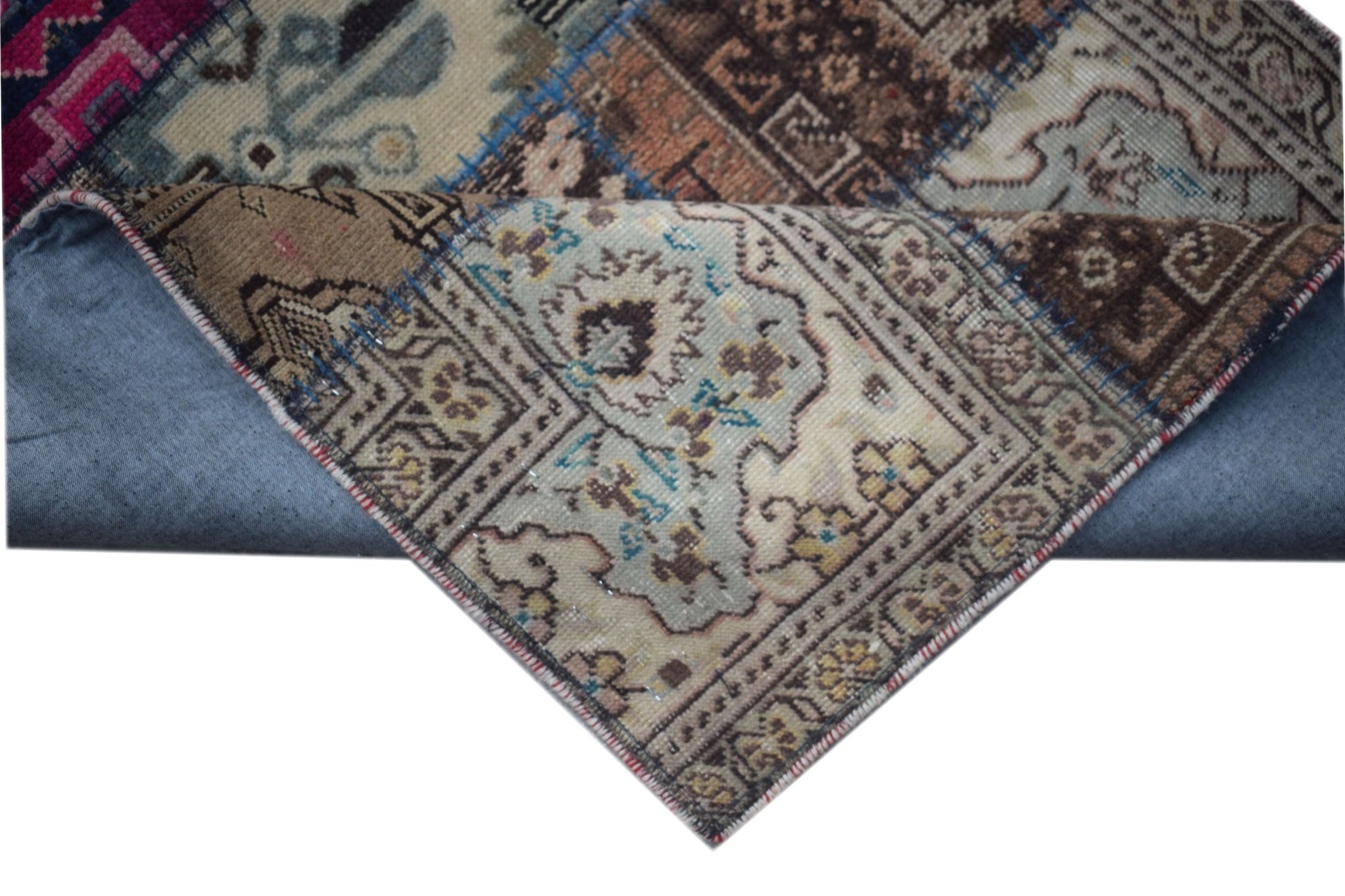 A handmade vintage patchwork runner featuring intricate wool patterns in muted earth tones.