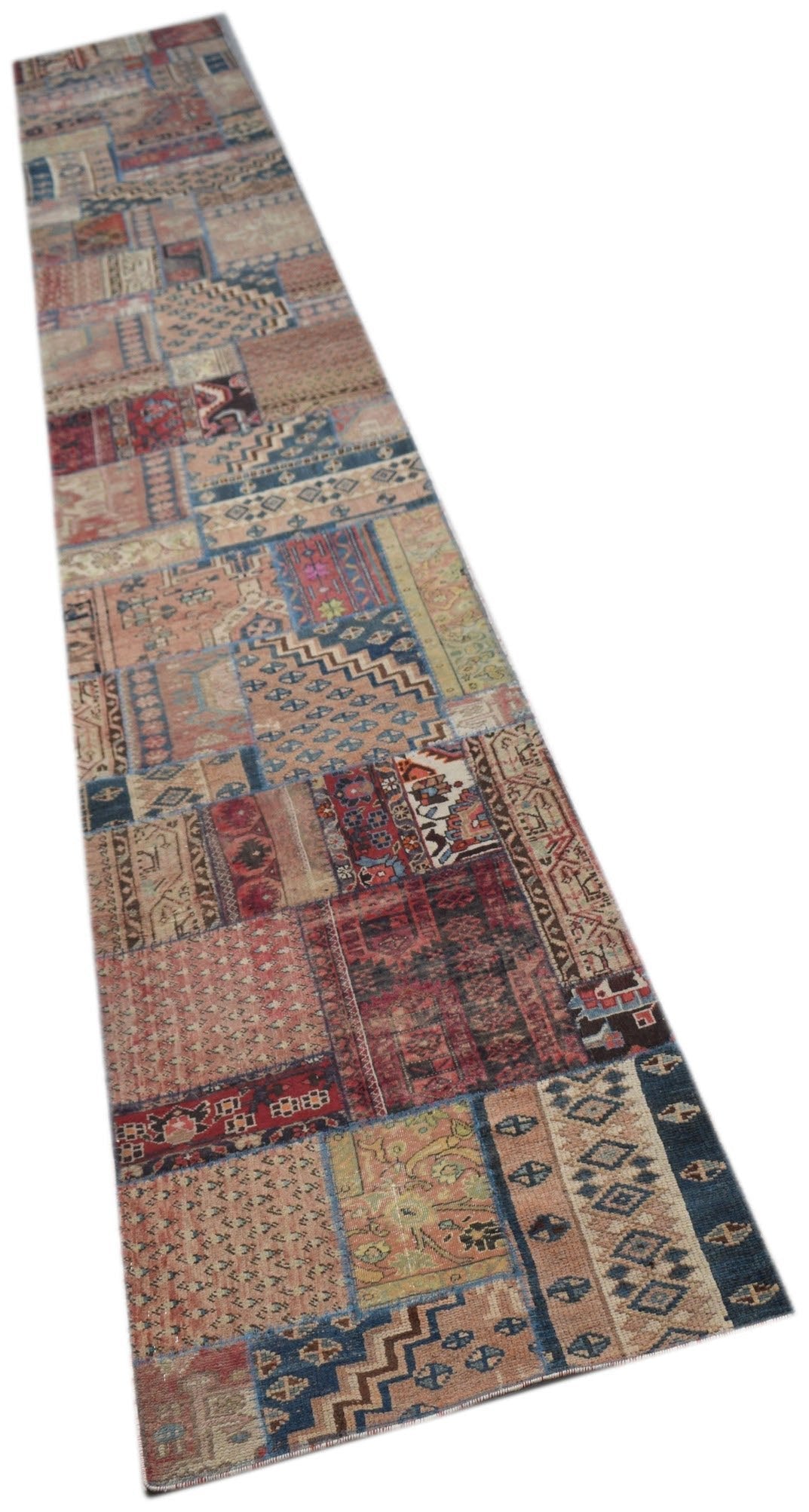 A long, handmade vintage patchwork runner rug featuring a variety of colorful, patterned wool panels.