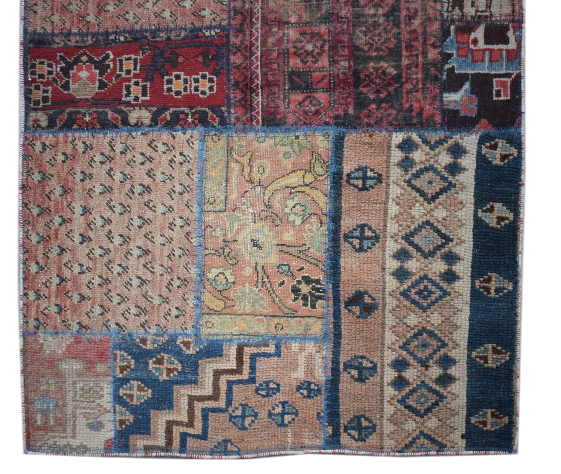 A handmade vintage patchwork runner featuring a variety of colorful wool rug fragments.