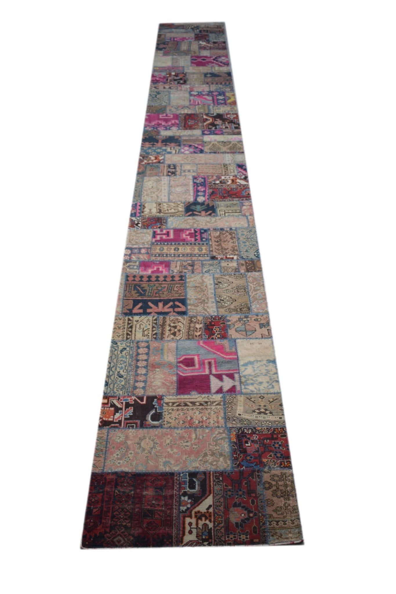 A long, handmade vintage patchwork runner rug featuring a colorful variety of wool patterns.